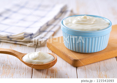 homemade organic yogurt in a ceramic bowl with spoon on a light background, selective focus. 115541093