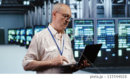 Focused IT support executive in data storage company equipped to handle complex computational operations, doing checking on server devices, verifying efficiency parameters to prevent liabilities 115544028