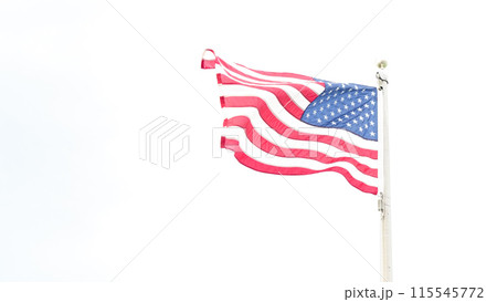 Beautiful American flag waving in the wind, with vibrant red white and blue colors against blue sky, with copy space. 115545772