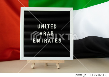 Message UNITED ARAB EMIRATES on background waving flag of UAE. National holiday, Independence Commemoration Day Muslim, congratulations. Arabian holidays. Advertisement 115546319
