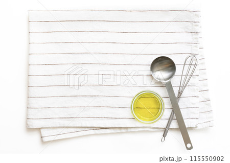 オリーブオイル、計量スプーン、ミニ泡立て器を乗せた白地ストライプリネン オリーブオイル、計量スプーン、ミニ泡立て器を乗せた白地ストライプリネン 115550902