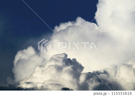 青空に現れた入道雲が大きく不気味に発達してきている 115551619