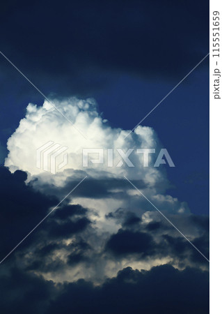 青空に現れた入道雲が大きく不気味に発達してきている 115551659