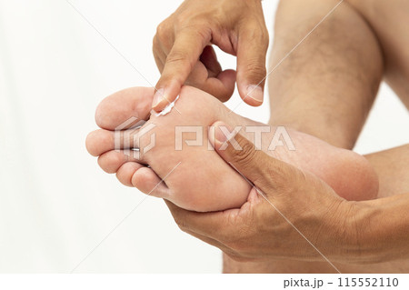 足に薬を塗る手元 白バック 足に薬を塗る手元 白バック 115552110