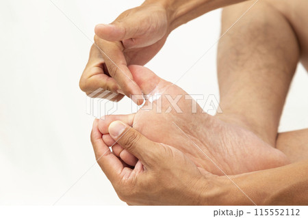 足に薬を塗る手元　白バック 115552112