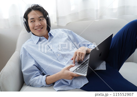 リビングでくつろぐ若い男性 リビングでくつろぐ若い男性 115552907