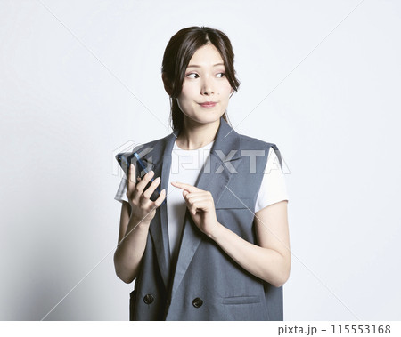 白バックのスマホを持っているおしゃれな女性 白バックのスマホを持っているおしゃれな女性 115553168