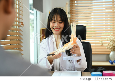 Professional orthopedic doctor explaining to patient about treatment, pointing at model of ankle and foot bones Professional orthopedic doctor explaining to patient about treatment, pointing at model of ankle and foot bones 115553679