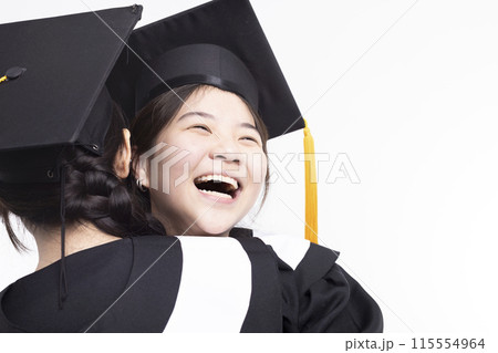 Happy high school girl friend graduates hugging in cap and gown Happy high school girl friend graduates hugging in cap and gown 115554964