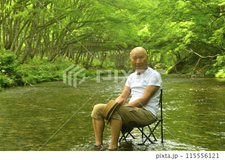 夏に渓流で水に浸かり涼を楽しむシニア男性 夏に渓流で水に浸かり涼を楽しむシニア男性 115556121