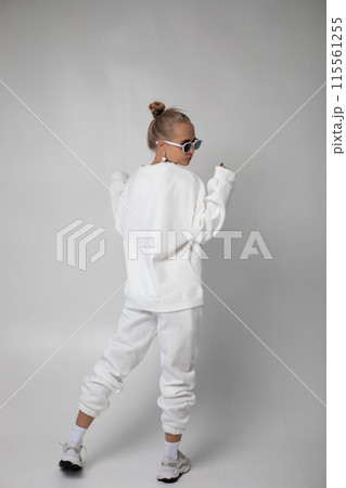 Beautiful blonde girl in sunglasses and hoodie posing on a white background Beautiful blonde girl in sunglasses and hoodie posing on a white background 115561255