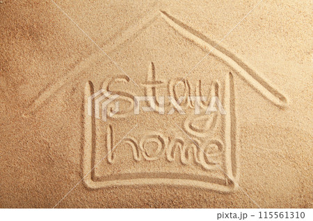 The inscription stay home on the sandy beach. Top view 115561310