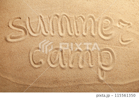 Inscription summer camp on beach sand. Top view 115561350
