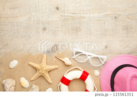 Beach hat with seashells and sand on light background Beach hat with seashells and sand on light background 115561351