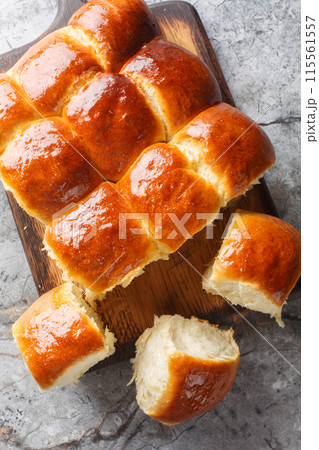 Close-up of Hawaiian sweet rolls, portuguese sweet bread on the wooden board on the table. Vertical top view 115561557