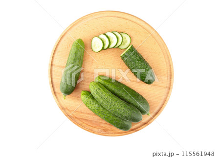Fresh cucumbers on a wooden cutting board isolated on white background Fresh cucumbers on a wooden cutting board isolated on white background 115561948