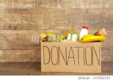 Donation box with food on the brown background 115562152