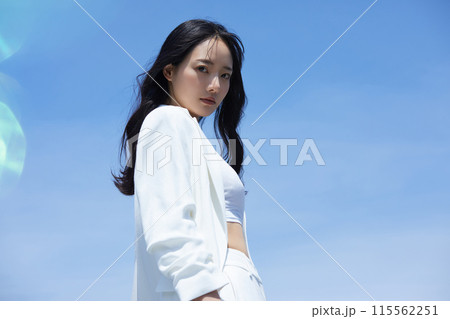 空背景で撮影をした白いジャケットを着た若い女性のポートレート 空背景で撮影をした白いジャケットを着た若い女性のポートレート 115562251