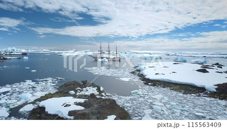Travel to Antarctica, expedition on wooden yacht. Boat tour South Pole. Explore arctic wild nature in sunny day. Polar ocean, icebergs, blue sky. Winter holiday vacation background. Aerial drone shot Travel to Antarctica, expedition on wooden yacht. Boat tour South Pole. Explore arctic wild nature in sunny day. Polar ocean, icebergs, blue sky. Winter holiday vacation background. Aerial drone shot 115563409