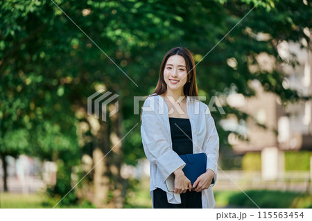 手帳を持って歩く若い女性 手帳を持って歩く若い女性 115563454