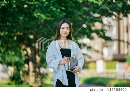 手帳を持って歩く若い女性 手帳を持って歩く若い女性 115563462