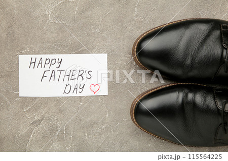 Happy Fathers Day message and black shoes on concrete wooden background. 115564225