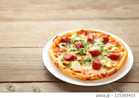 Tasty Italian pizza with sausage on grey wooden table with copy space 115565415