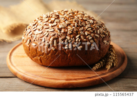 Wholegrain rye bread on a cutting board on grey background Wholegrain rye bread on a cutting board on grey background 115565437