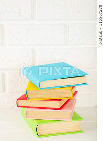 Multi coloured school books on a white background with copy space. 115567279