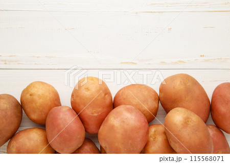Potatoes on white wooden background, top view Potatoes on white wooden background, top view 115568071