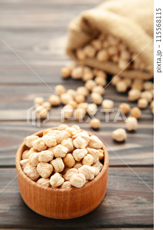 Uncooked chickpea in bag and bowl on brown wooden table. Top view Uncooked chickpea in bag and bowl on brown wooden table. Top view 115568115