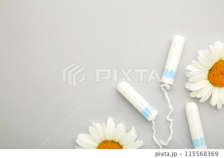 Medicinal chamomile flower and menstrual sanitary tampon. Woman critical days, gynecological menstruation cycle. Medicinal chamomile flower and menstrual sanitary tampon. Woman critical days, gynecological menstruation cycle. 115568369