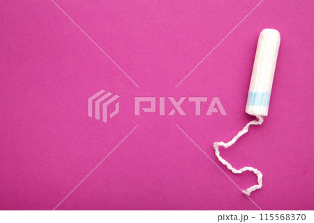 Menstrual tampon on a pink background. Cotton tampon for women Menstrual tampon on a pink background. Cotton tampon for women 115568370