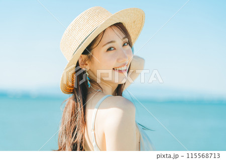 海と青空バックの麦わら帽子を被った女性 115568713
