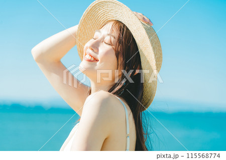 海と青空バックの麦わら帽子を被った女性 115568774