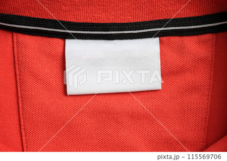 Blank white laundry care clothes label on orange shirt fabric texture background 115569706