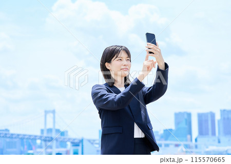 スマートフォンを操作する若いビジネスウーマン 115570665