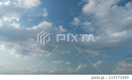 Cloud stratocumulus nature background. Blue sky with cumulus clouds and sun. Nature background of airy cloudscape. Timelapse. 115571940
