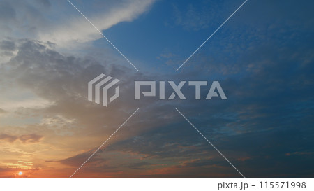 View of yellow sun setting in orange sky with dark clouds. Timelapse. View of yellow sun setting in orange sky with dark clouds. Timelapse. 115571998