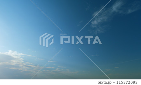 Building of a large white cloud in the blue sky. Clouds moving in blue sky with sun rays. Timelapse. 115572095