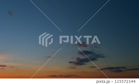 Panoramic view. Sunset sky with condensation trail. Dramatic warm near and far clouds at sunset. Timelapse. 115572144