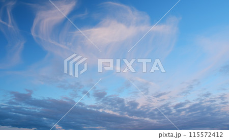 Intense dramatic panoramic sunset. Abstract different shades clouds at sunset sky background. Timelapse. 115572412