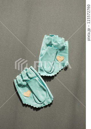 A pair of blue leather mittens with a white heart on the palm A pair of blue leather mittens with a white heart on the palm 115572760