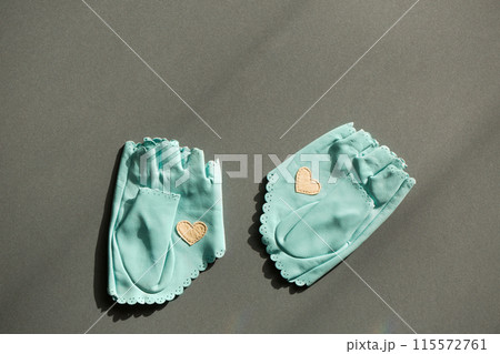 A pair of blue leather mittens with a white heart 115572761