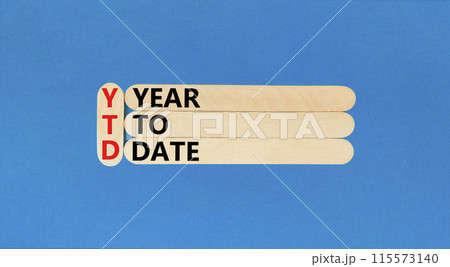 YTD year to date symbol. Concept words YTD year to date on beautiful wooden stick. Beautiful blue background. Business YTD year to date concept. Copy space. 115573140