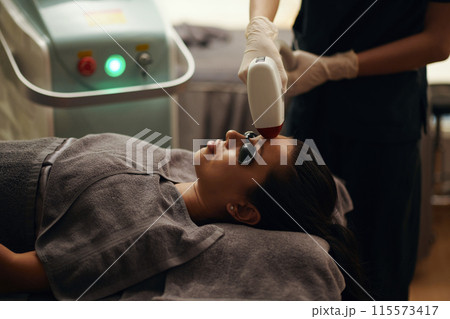 Cosmetologist Removing Facial Hair 115573417