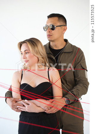 A young couple, a man and a woman, are wrapped in red threads. Dependency concept A young couple, a man and a woman, are wrapped in red threads. Dependency concept 115573525