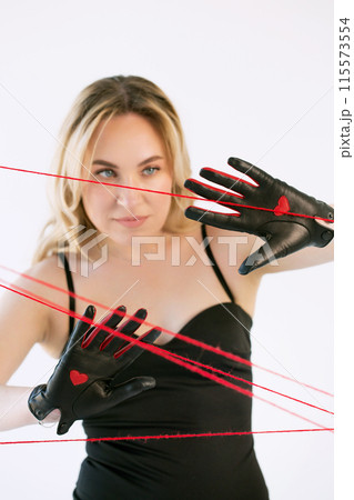 An adult woman in black gloves with a heart with red threads. 115573554