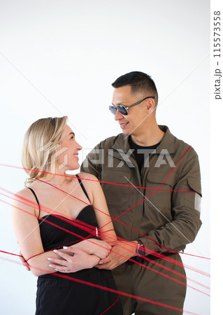 A young couple, a man and a woman, are wrapped in red threads. Dependency concept A young couple, a man and a woman, are wrapped in red threads. Dependency concept 115573558