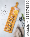 oysters scallops with red sea salt and citric acid on a wooden tray side view 115574380